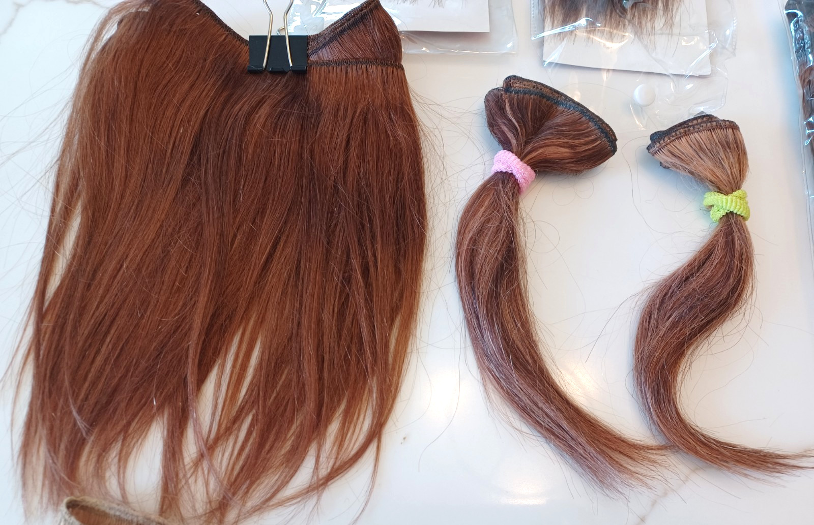 Lot of 18 Hair Extensions. Brunette/red-black-blonde. Some human hair.